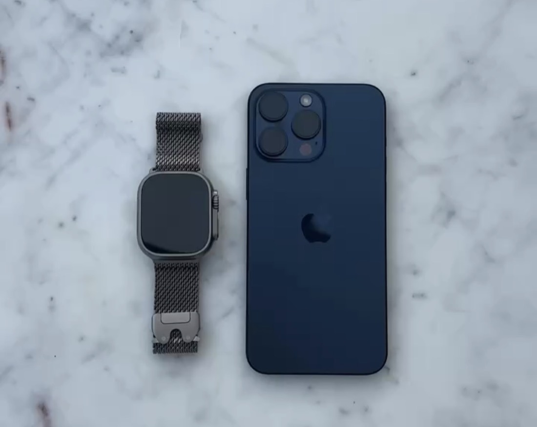 iPhone 15 Pro Max and Apple Watch on marble